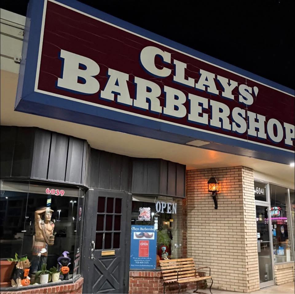 Clay's Barbershop storefront at night, lit sign at 6039 S Sheridan Rd